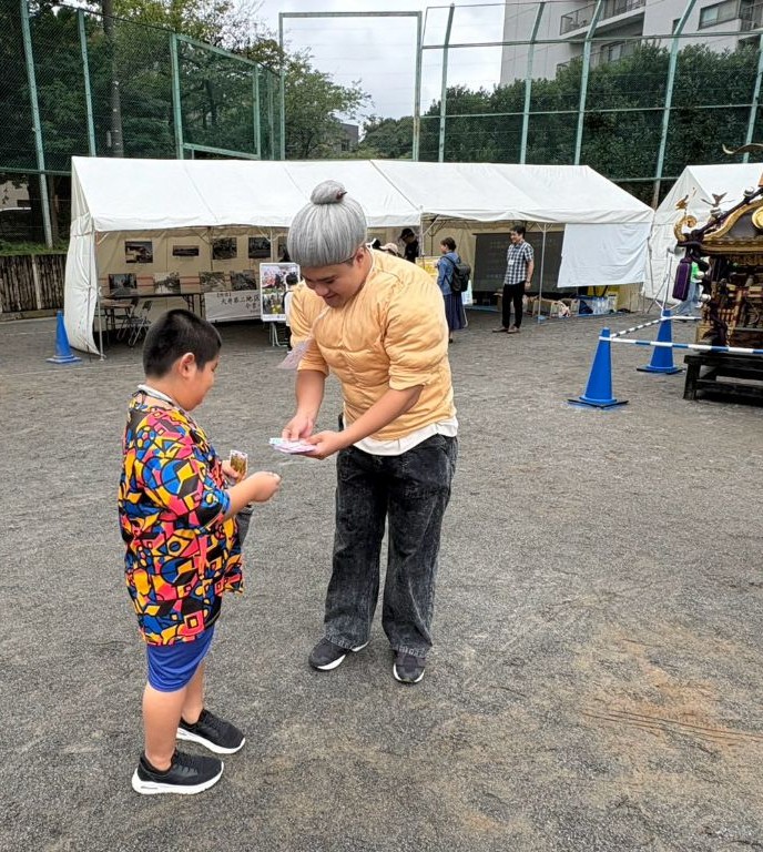 地域のお祭りでこどもと交流する学生スタッフ