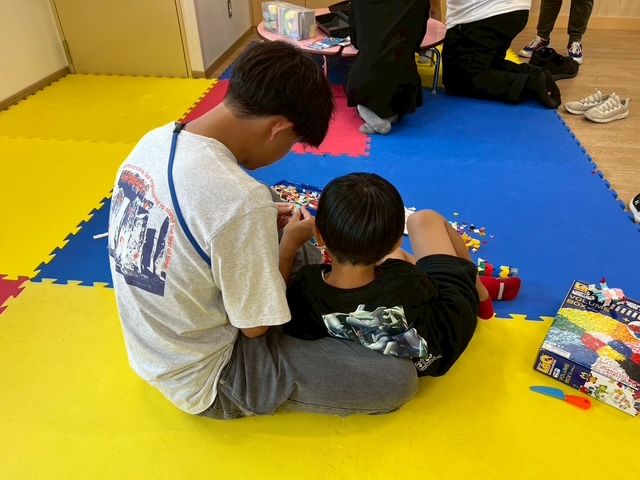 学生とこどもがブロックで遊ぶ様子
