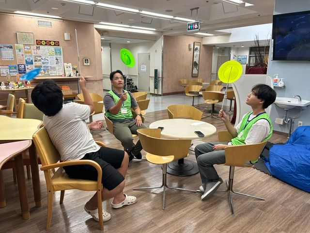 学生スタッフとこどもが皿回しに挑戦する様子